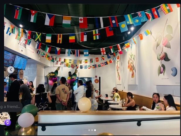 Guests enjoying the café beneath rows of international flags during the grand opening