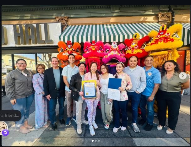 The Xóm Cà Phê grand opening group celebrating outside the café with colorful lion dance costumes